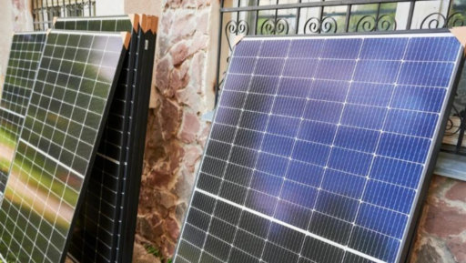 Válogatott napkollektor panelek tárolva egy ház előtt készen az otthoni telepítésre, megújuló energia használatra